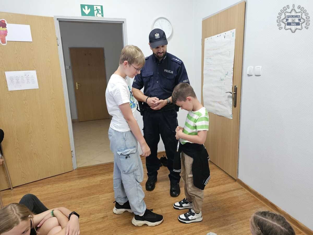 Aspirant Witold Lisiak z żorskiej Policji przeprowadził zajęcia z dziećmi z półkolonii w świetlicy „Smok” / fot. KMP Żory